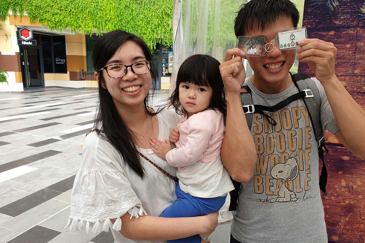 Guests holding their photo keychains at a Singapore event