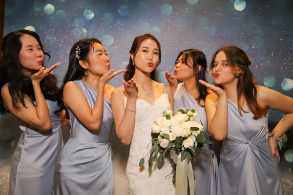 Wedding guests posing with props at photobooth